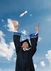 Image showing graduate in cloak throwing diploma