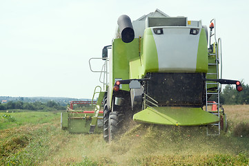 Image showing working harvesting combine in field