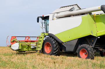 Image showing working harvesting combine in field