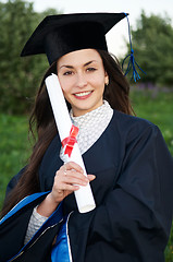 Image showing Happy Young smiley graduate girl outdoors