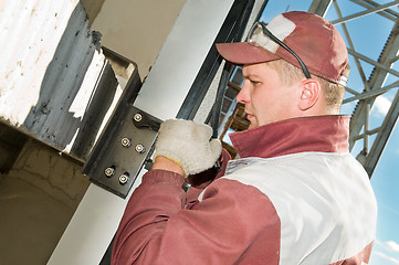 Image showing builder with wrench and screws