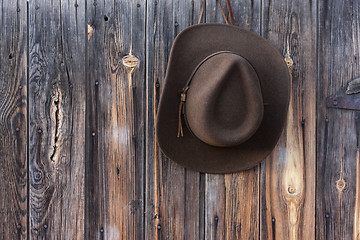 Image showing felt cowboy hat on barn wall 