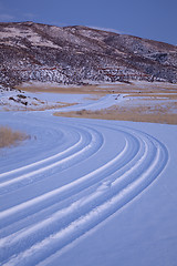 Image showing windy country road covered by snow in mountain valley 