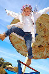 Image showing autumn coat and hat dressed child jumping