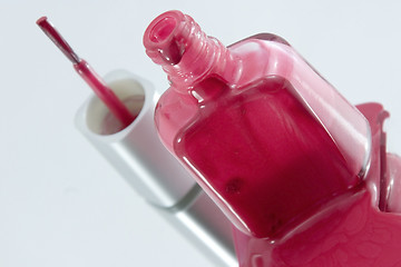 Image showing Nail Polish Spilling on a Mirror with the Brush Standing at an A