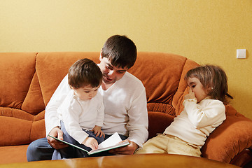 Image showing Dad reading book to daughters