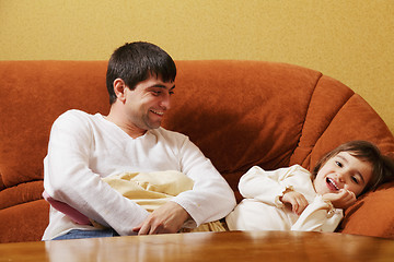 Image showing Father sitting with daughter on sofa