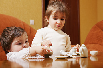 Image showing Sisters playing with dishware