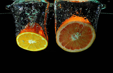 Image showing Grapefruit and ornage falling into water