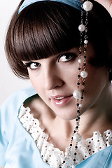 Image showing brunette woman in blue dress with pearl beads