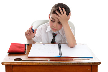 Image showing Boy thinkinhg at school desk