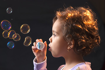 Image showing little girl playing with soap bubbles 