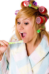 Image showing funny housewife with curlers and toothbrush 