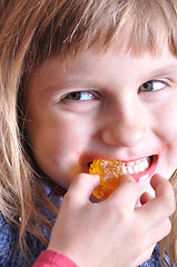 Image showing child biting a sweet 