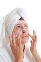 Image showing woman putting cream on her face