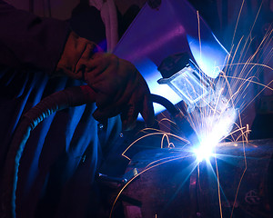 Image showing Dramatic blue-lit MIG welding close