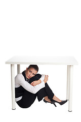 Image showing Depressed business woman hiding under a table