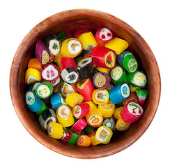 Image showing Varicoloured lollipop in brown wooden plate