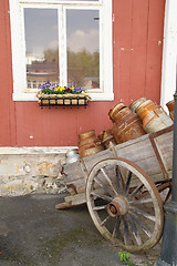 Image showing Old cart with milk cans near the house