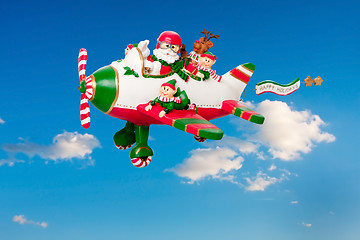 Image showing Flying Santa Claus with Elves in Airplane
