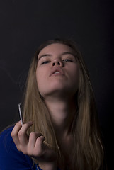 Image showing portrait of a young girl with cigarette  
