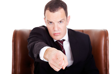 Image showing Angry businessman seated on a chair, pointing