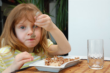 Image showing child eating boild buckwheat