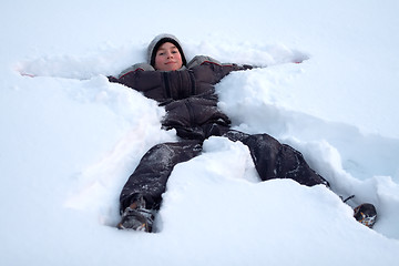 Image showing Happy Boy Laying In Fresh Snow