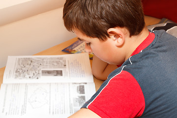 Image showing boy doing homework, reading text from workbook