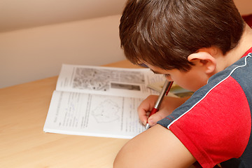 Image showing boy doing homework, writing text from workbook