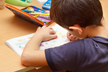 Image showing boy doing homework  with color pencil, painting fruits