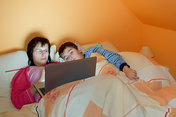 Image showing Portrait of a mother and her son using laptop while lying on the bed at home 
