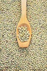 Image showing Wooden spoon and dried green lentils