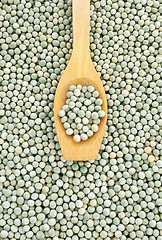 Image showing Wooden spoon and dried green split peas