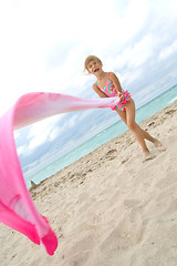 Image showing child playing with a cloth at the beach