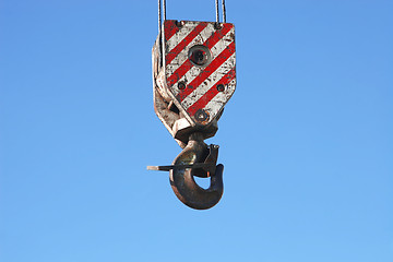 Image showing rusty crane hook and steel cables hanging on blue sky