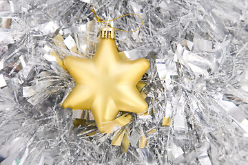 Image showing golden star, christmas decoration on silver tinsel