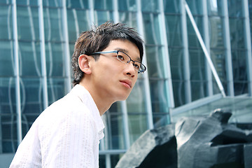 Image showing business man on modern glass building background