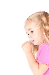 Image showing Little cute girl in studio eating candy