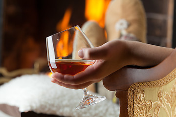 Image showing Resting at the burning fireplace fire with a glass of cognac