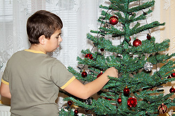 Image showing Young boy holding Christmas decorations