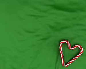 Image showing Heart made from christmas candies on green background