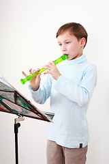 Image showing Little boy playing flute