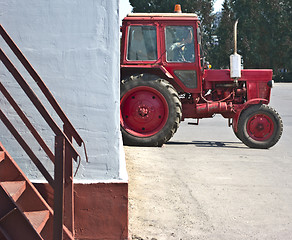 Image showing red tractor resting in a white wall