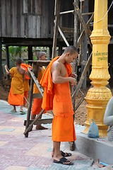 Image showing Monks fixing a lamp