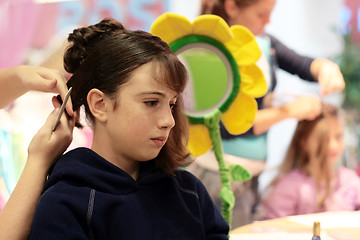 Image showing A girl getting her hair done