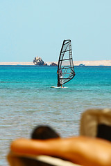 Image showing Man tans on windsurfing background
