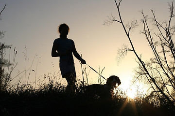 Image showing Girl and her dog at sunset