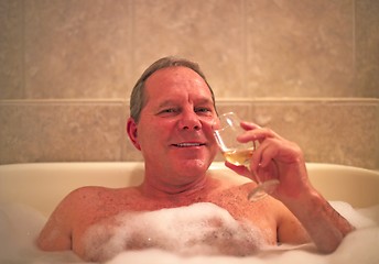 Image showing A man with a glass of wine enjoys his relaxing jacuzzi bath in a resort hotel. Model released. (14MP camera)