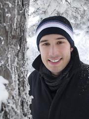 Image showing young man smiling in winter park 